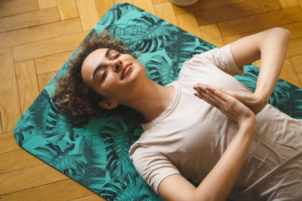 istock Mixed-race woman meditates lying down 2149000794