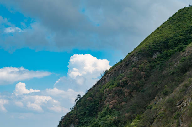 Mountain slopes and blue sky with white clouds.