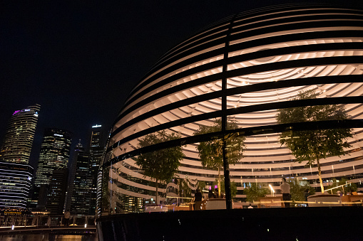 Singapore - 20 October 2022: Apple Marina Bay Sands at night with lighting inside. It is the World's First Floating Apple Store, designed by Foster + Partners.