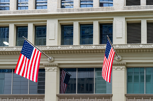 The American flag flies in from of a classic city hall.