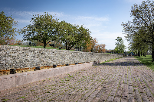 The pedestrian trail in Thoroughbred Park, Lexington, Kentucky, is paved with stones and flanked by a restraining wall.