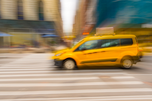 Street photography near Grand Central Station, New York City.  Slow shutter speed and zooming out with a wide angle zoom lens creates movement blur for intentional camera movement and give an abstract background.