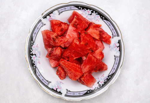 Fresh watermelon slice on a plate on white background. Locally in Bangladesh, it is called Tormuj. Top view