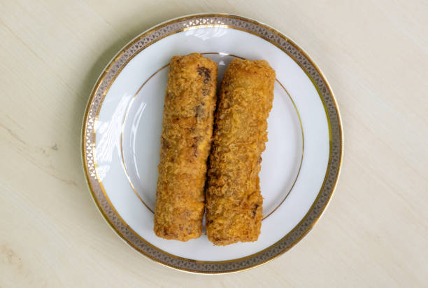 istock Fried chicken spring rolls on white plate on wooden background. Top view 2149005486