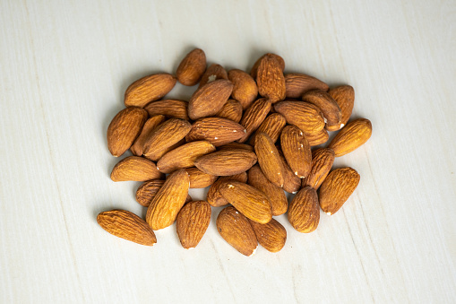 Almond nuts isolated on a wooden background. Almonds are a healthful food. Locally in Bangladesh, it is called Kath Badam.