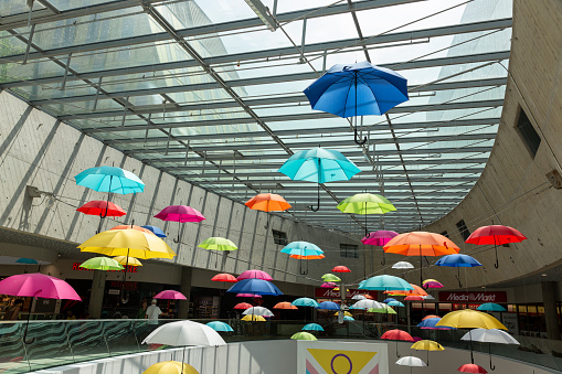 Vienna, Austria - June 22, 2023: Installation of colorful umbrellas under the roof of the shopping center