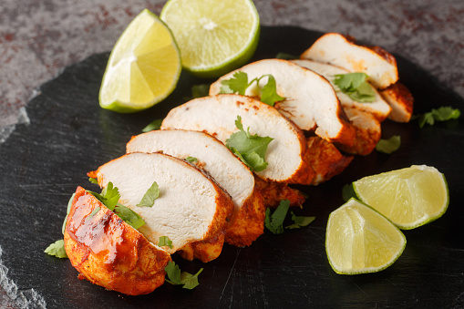 Chipotle chicken is smoky, spicy and a bit tangy from the lime juice closeup on a slate plate on the table. Horizontal