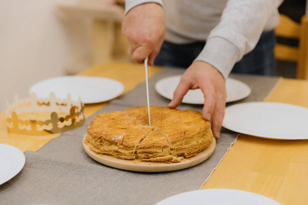 istock A young man cuts a royal galette at the table. 2149009567