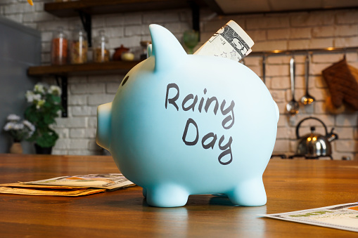 Blue piggy bank and savings for rainy day.