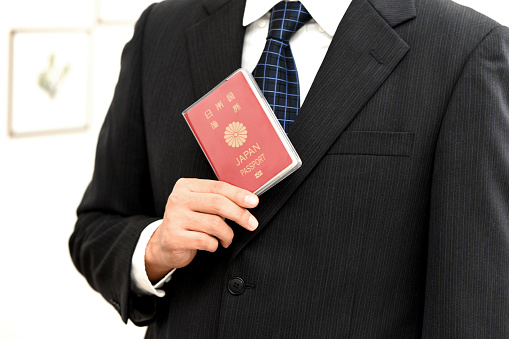 Hand of a businessman holding a passport
