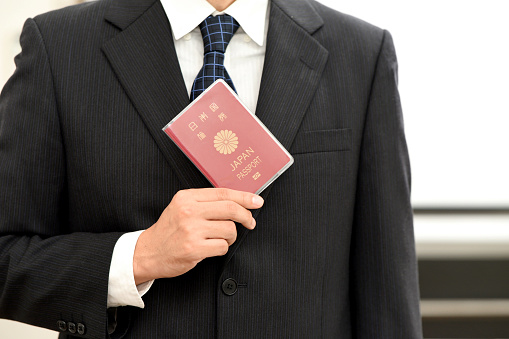 Hand of a businessman holding a passport