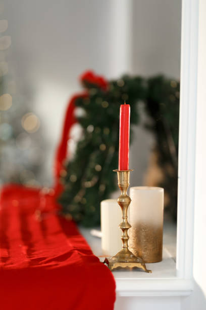 Red candle in a golden candlestick on the table