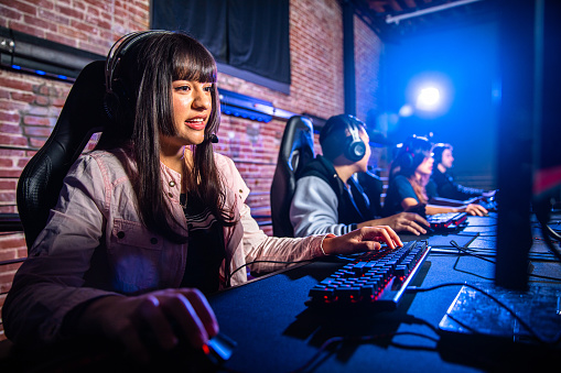 Young college students playing esports at computer stations