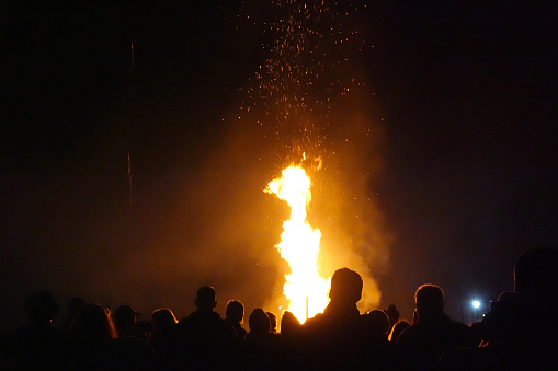 People silhouetted in front of bonfire.