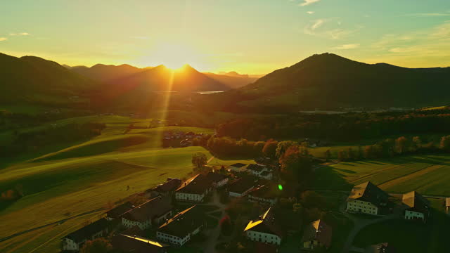 Golden Hour Light Over Countryside Village In Austria Alps, Central Europe. Aerial Shot
