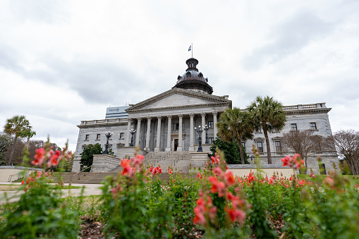 The South Carolina State House Building in Columbia. Low-angle view with flowers in the foreground.