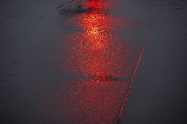 istock reflections of a red traffic light on wet asphalt 2149015027