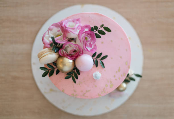 テーブルの上に花が飾られたピンクのケーキ。