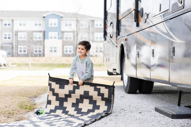 istock Young boy helps fold up the outdoor rug 2149017600