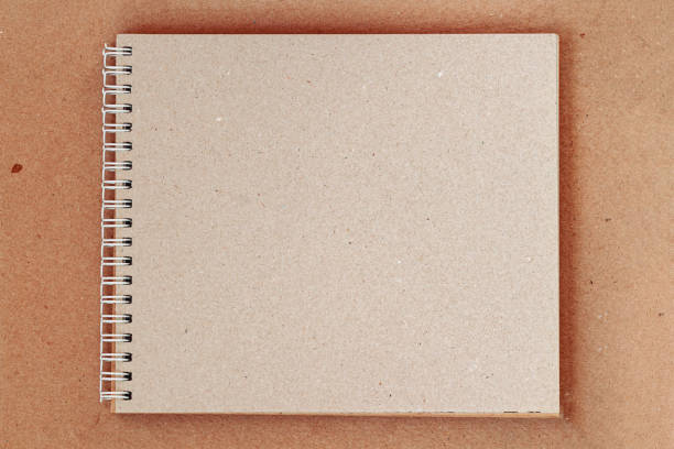 Open sketchbook with craft paper on spiral, vintage background