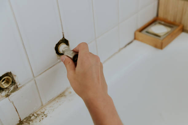 istock A young man takes out a faucet nut from the wall. 2149019310