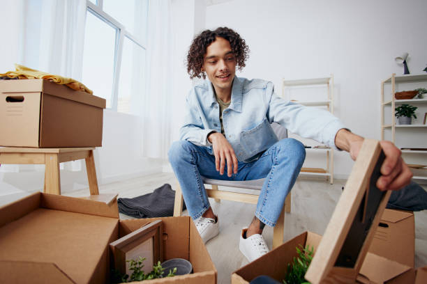 istock A young man sitting on a chair with boxes moving Lifestyle 2149019399