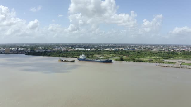 Wide orbiting aerial viewpoint of tanker ship captured with drone mavic 2 pro. Over Suriname river in port of Paramaribo, capital of Suriname