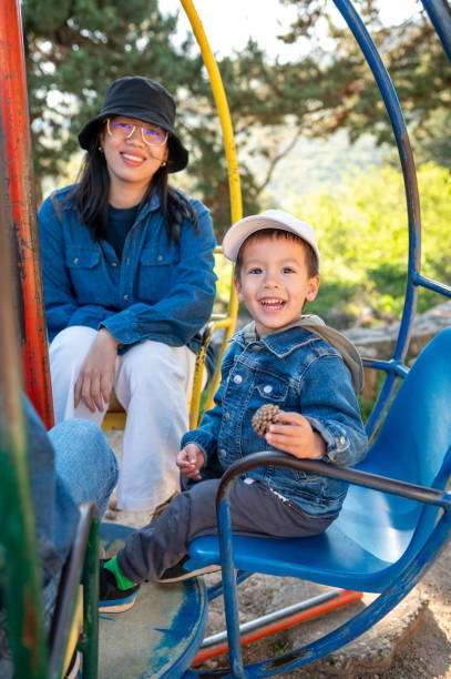 istock Joyful carousel ride with boy and his mom in park 2149020586