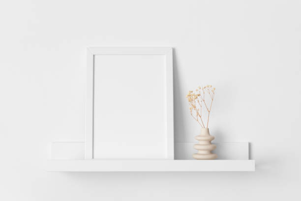 istock White frame mockup with a gypsophila decoration on the wall shelf. 2149021491
