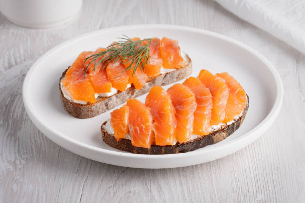 istock Rye sandwich with salmon and cream cheese on white wooden table 2149021751
