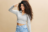 You Are Next. Cheerful Young Latin Woman Pointing Finger At Camera, Happy Beautiful Millennial Female Indicating Somebody, Saying Gotcha While Posing Over Beige Studio Background, Copy Space