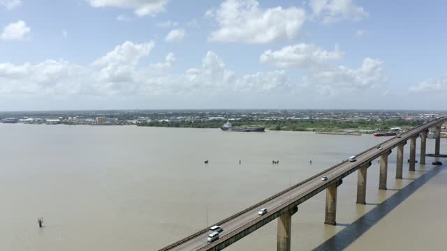 Wide angle aerial shot of Jules Wijdenbosch Bridge between Paramaribo and Meerzorg in Suriname, South America, with traffic as drone flies over bridge