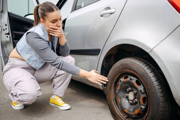 istock Woman worried for having a flat tyre while on the road 2149025378
