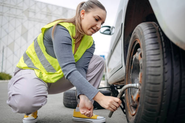 istock Woman changing flat tyre on her car 2149025656