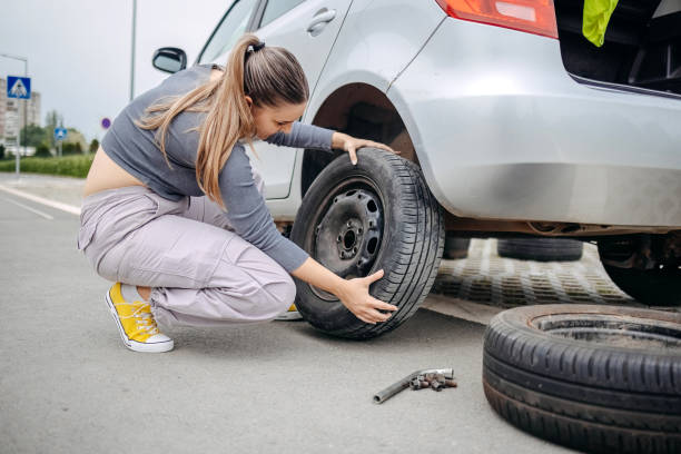 istock Woman changing flat tyre on her car 2149025746
