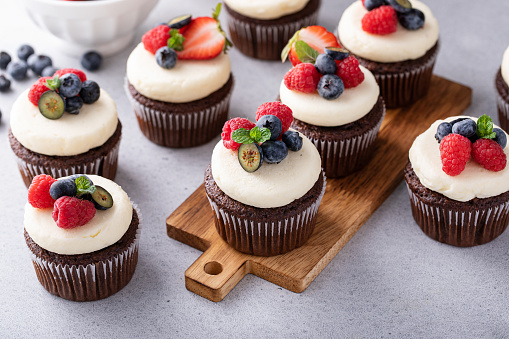 Chocolate cupcakes with vanilla frosting and fresh berries on top