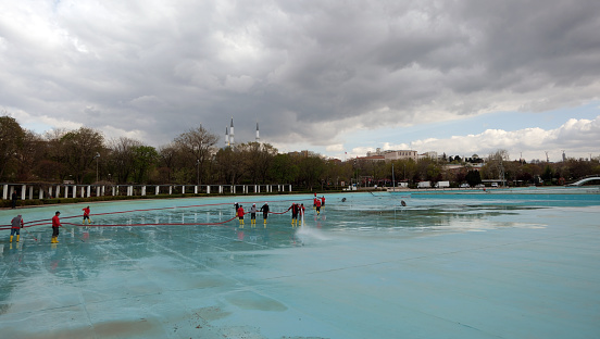 Workers cleaning the pool in Genclik Park in Ankara. Ulus, Ankara Türkiye - April 16 2024: