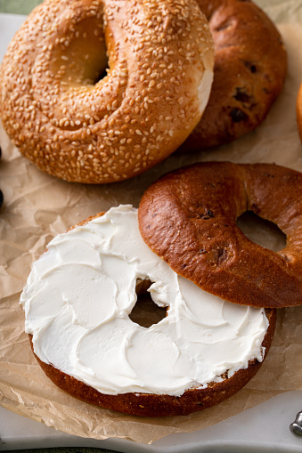 Cinnamon raisin bagel topped with cream cheese for breakfast