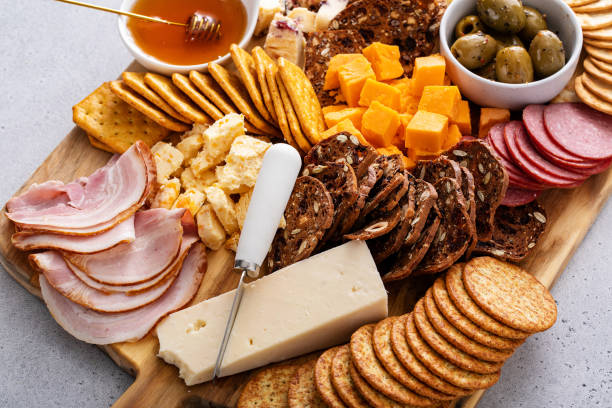 istock Cheese and snacks board with charcuterie, crackers and variety of snacks 2149030130