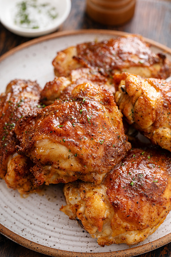 Chicken thighs roasted or air fried with paprika, spices rub and lime on a plate