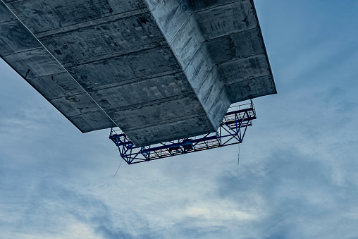 concrete bridge under construction, seen from below with the roadway suspended in the air against a blue sky, Crown Princess Marys bridge Frederikssund, Denmark, December 2018