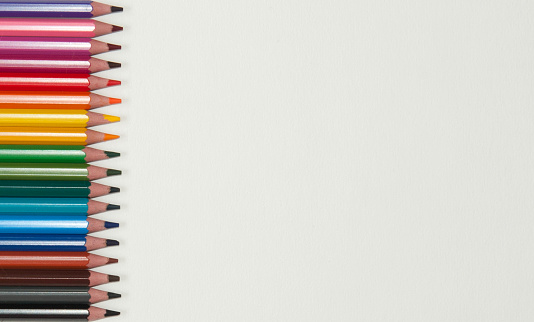 Colored pencils, also known as pencil crayons, arranged on a surface.