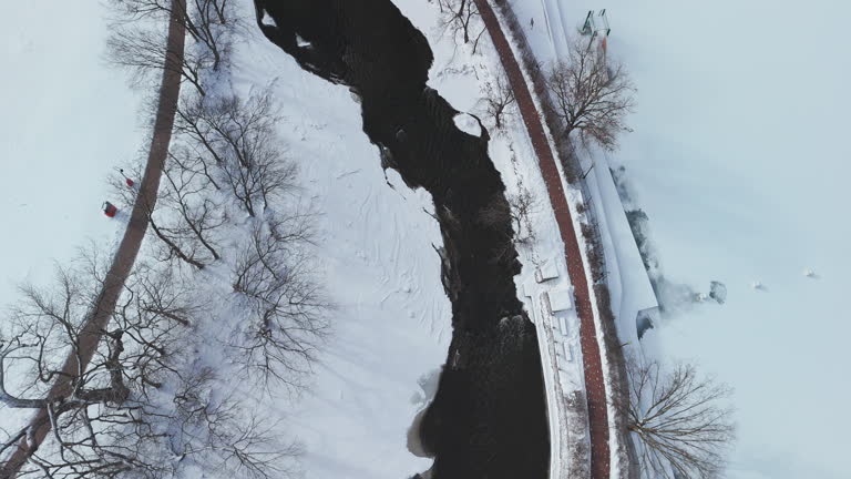 Aerial shot of a winter river, the banks are covered with snow