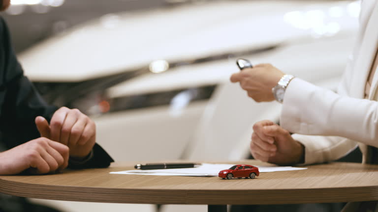 The buyer enters into an agreement to purchase a new car at the dealership. Cars in the showroom, transport rental, sale and purchase.