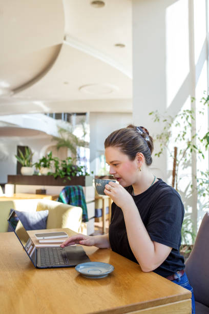 istock Casual Businesswoman Drinking Coffee and Using Laptop 2149033475