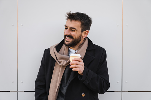 Portrait of a man drinking coffee outside on a white background