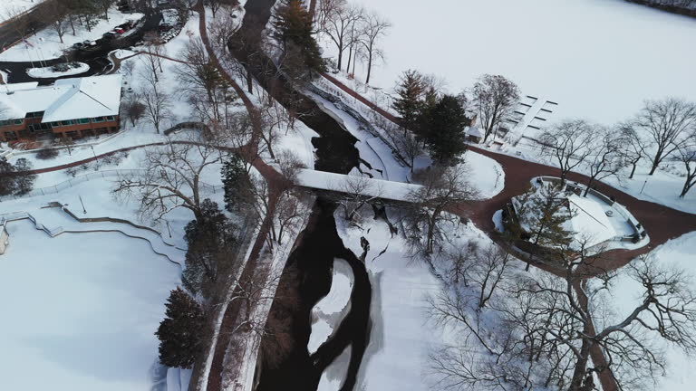 Aerial wide shot of a winter river, the bridge are covered with snow