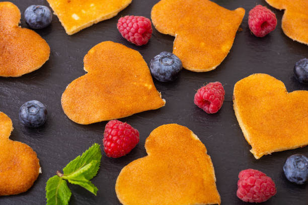 Mini pancakes hearts with berries . Delicious breakfast . Food background . Valentine's Day