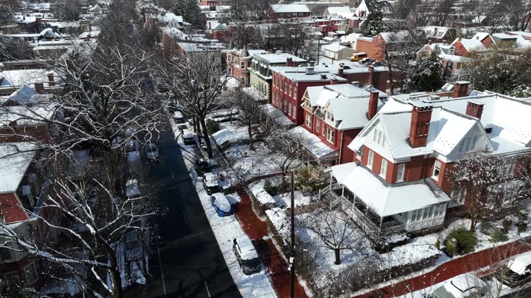 Historic houses covered in snow during winter. Aerial shot of American city housing.