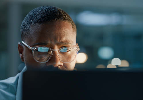 Face, black man with glasses and computer for working in office for planning, reading and technology for connection. Businessman, programmer and laptop for research, problem solving and manage seo